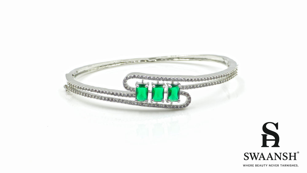 Silver-finish bracelet with three emerald-cut green stones and double pavé crystal swirl – Swaansh
