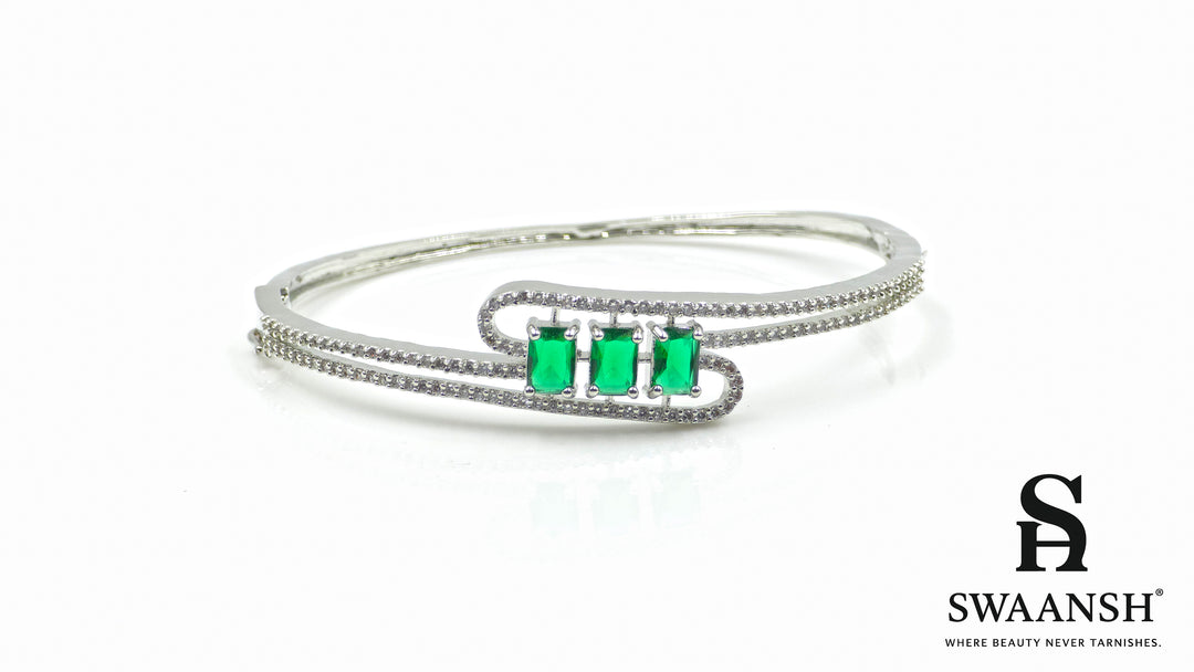 Silver-finish bracelet with three emerald-cut green stones and double pavé crystal swirl – Swaansh