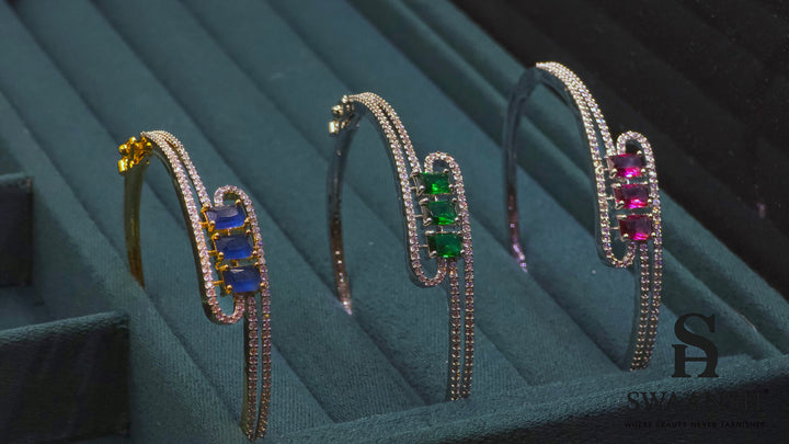 Silver-finish bracelet with three emerald-cut green stones and double pavé crystal swirl – Swaansh