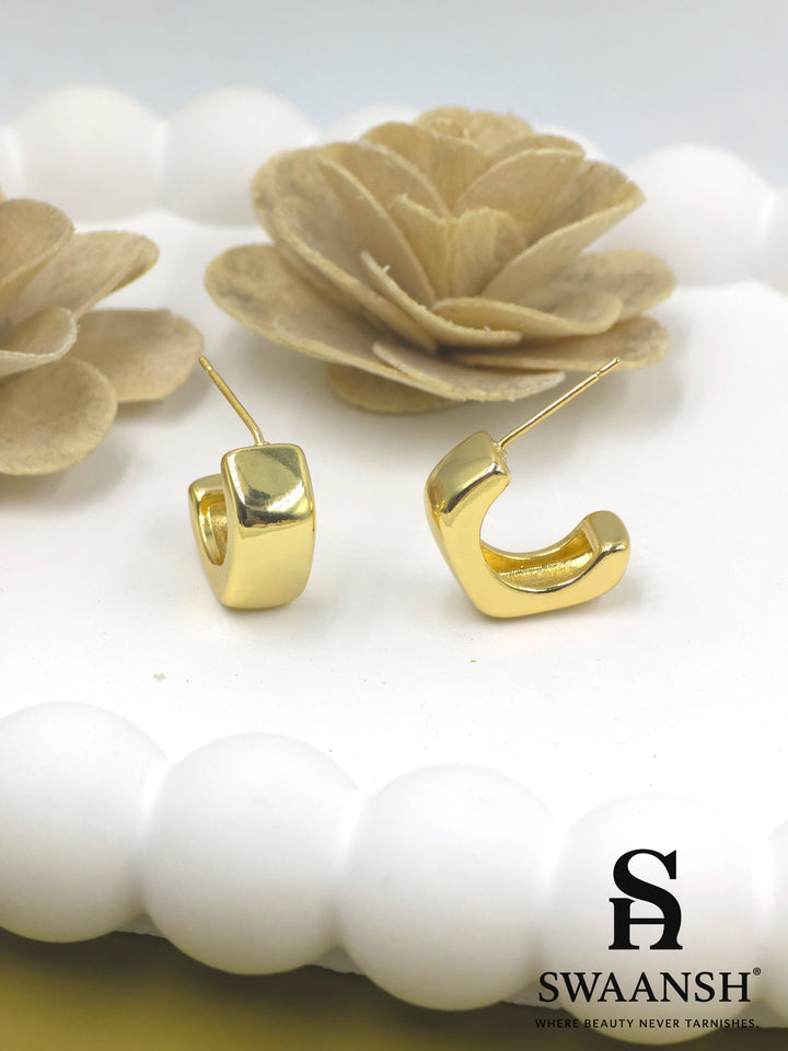 Swaansh Bold Drape earrings – smooth sculpted C-shaped gold mini hoops resting on white floral background