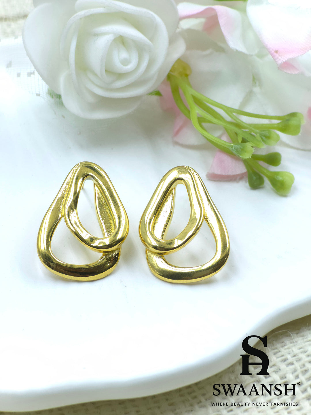RippleLinks sculpted drop link earrings with glossy gold finish by Swaansh, styled on a white ceramic backdrop