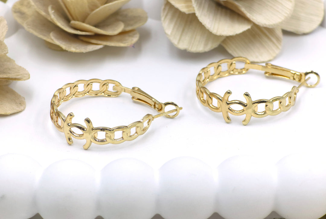 Celestia chain-link hoop earrings in gold finish placed on white shell-textured plate – bold and modern design from Swaansh anti-tarnish collection