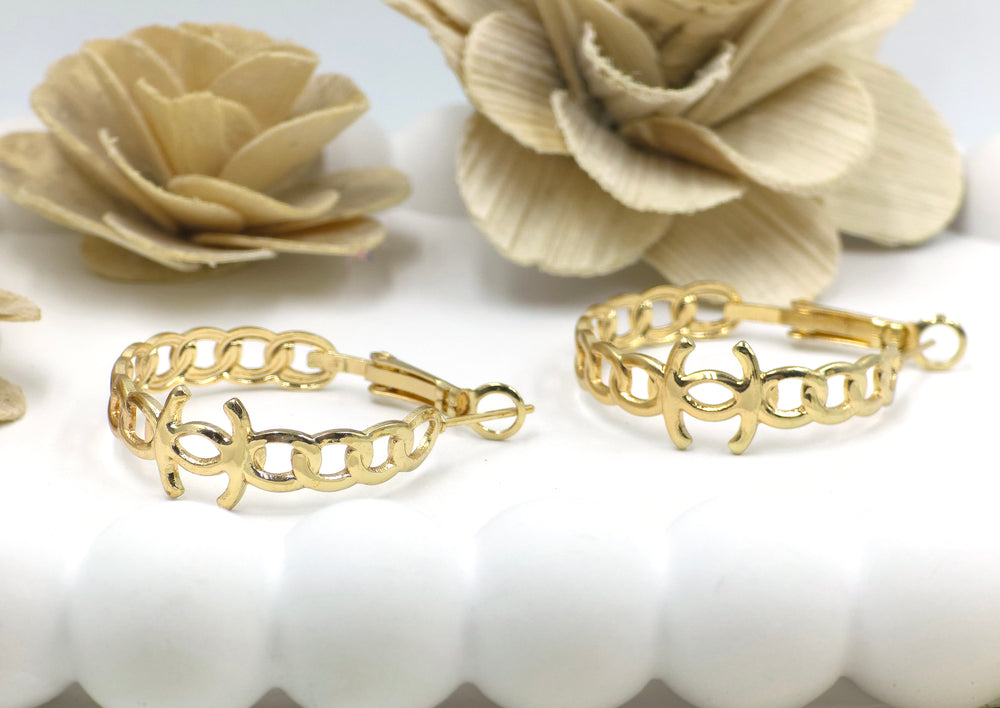 Celestia chain-link hoop earrings in gold finish placed on white shell-textured plate – bold and modern design from Swaansh anti-tarnish collection