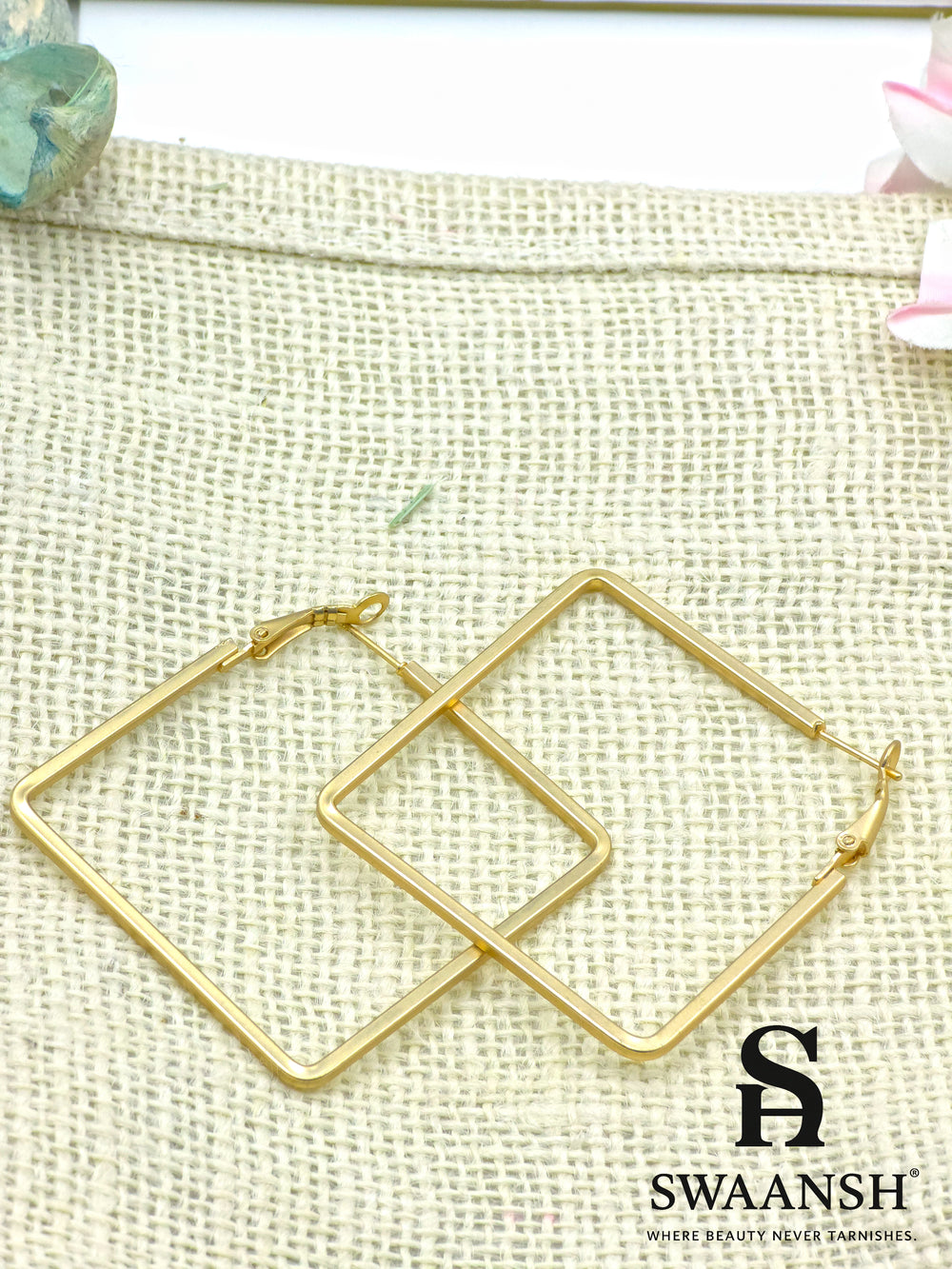 Frame It Bold square gold hoop earrings by Swaansh placed on white ceramic plate – edgy geometric design for everyday and party wear