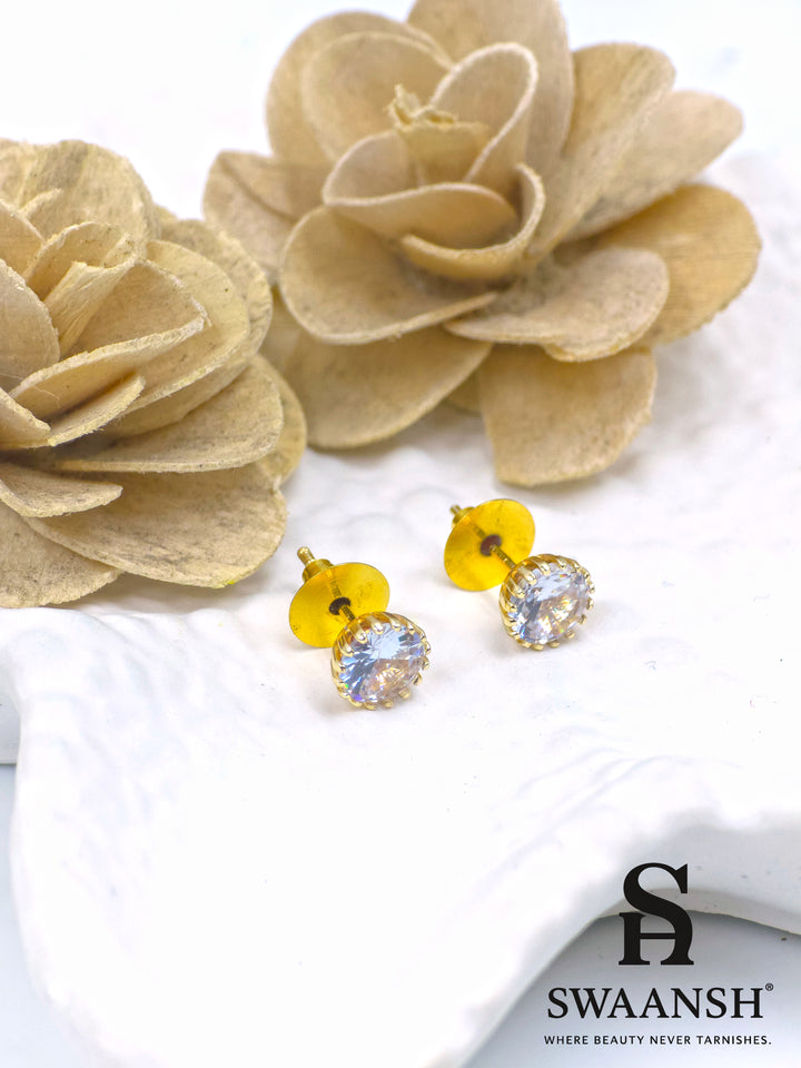 Crystal solitaire gold stud earrings placed on white ceramic plate – Swaansh