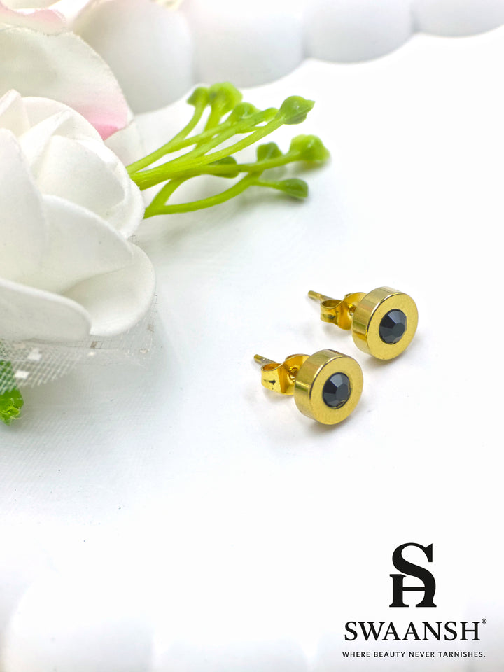 Black stone round stud gold earring – front view on white backdrop.
