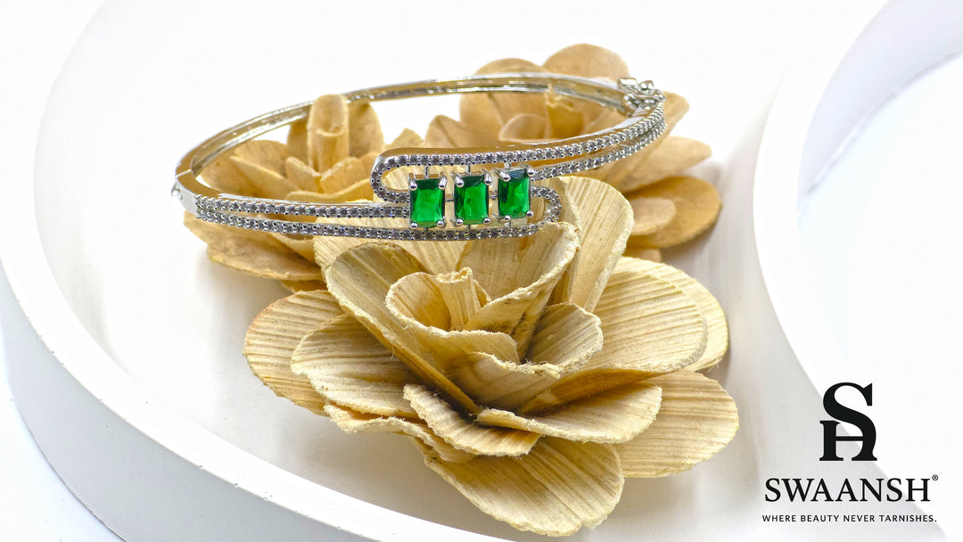 Silver-finish bracelet with three emerald-cut green stones and double pavé crystal swirl – Swaansh