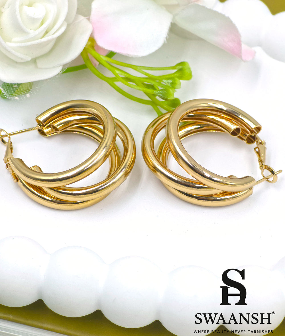 Bold Loop triple-band hoop earrings in gold by Swaansh, featuring thick layered design placed on a floral white base – ideal for statement wear