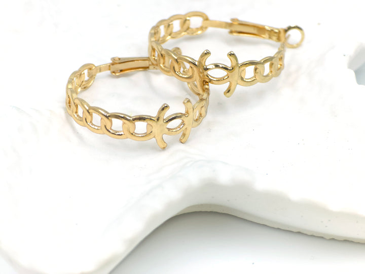 Celestia chain-link hoop earrings in gold finish placed on white shell-textured plate – bold and modern design from Swaansh anti-tarnish collection