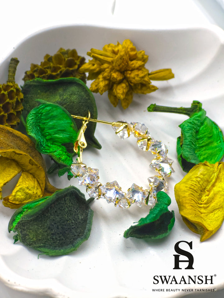 Crystal gold hoop earrings with prism-cut stones on white background – Swaansh 