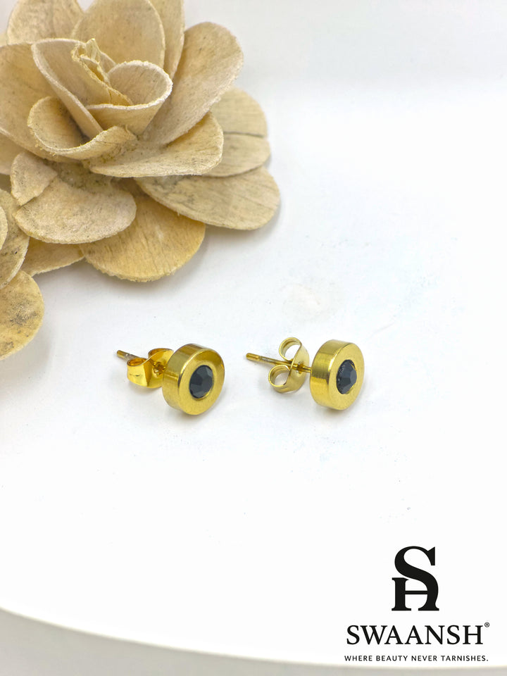 Black stone round stud gold earring – front view on white backdrop.