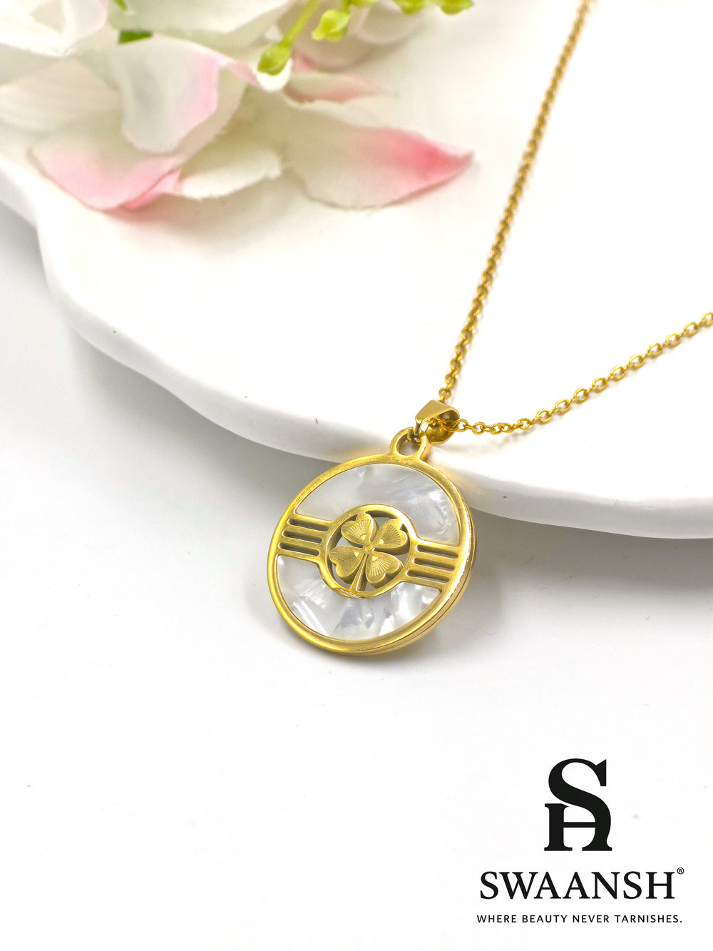 Gold-toned circular pendant with four-petal motif on mother-of-pearl base — Aura Shield Pendant by Swaansh