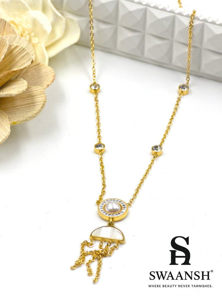 Lunar Drift Pendant by Swaansh featuring pearl center with crystal halo, half-moon charm, and gold tassel drops on crystal-dotted chain
