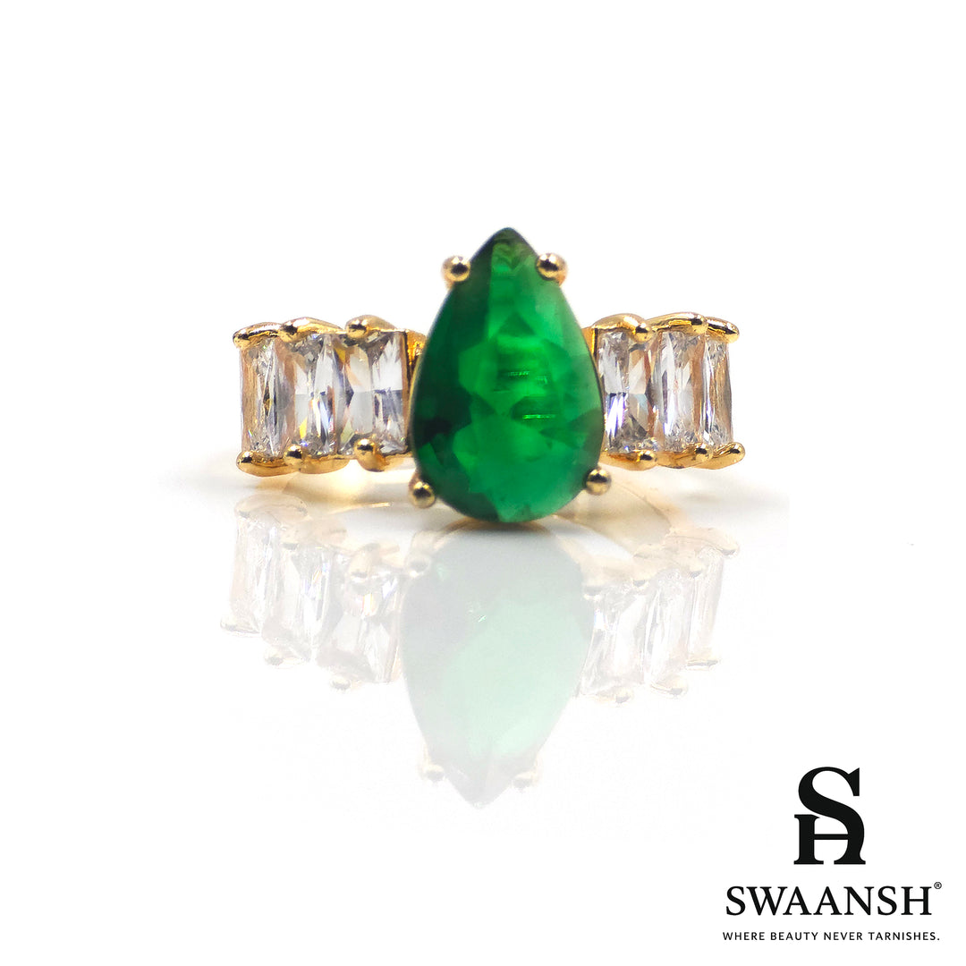 Gold ring with teardrop-shaped green stone and clear side zircons – The Emerald Royal Ring by Swaansh